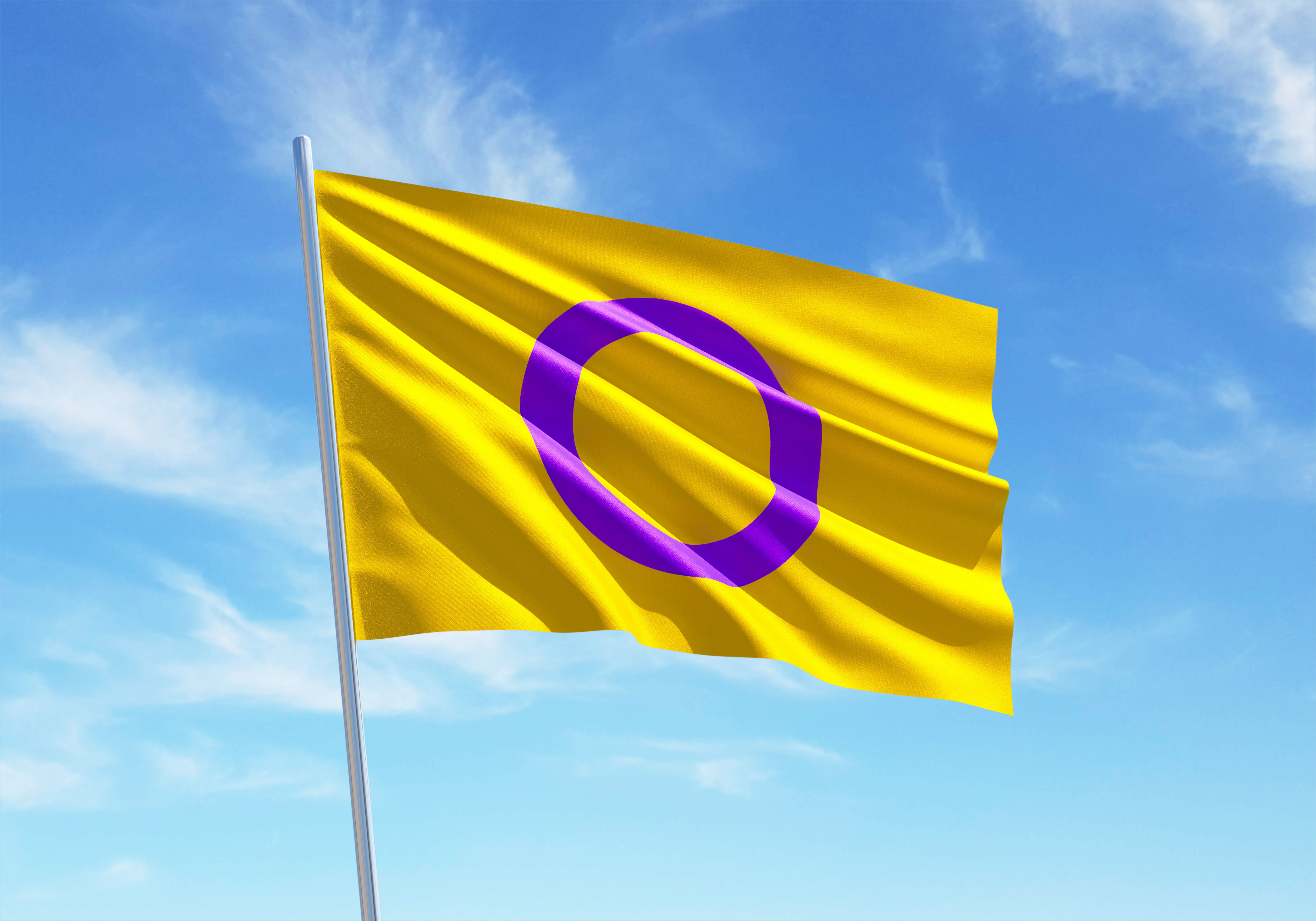 Bildet viser Intersex flagg, et flagg med en gul bakgrunn og en lilla sirkel i midten. Det vaier i vinden mot en blå himmel med noen skyer. «KI-generert bildetekst, kvalitetssikret før publisering.»